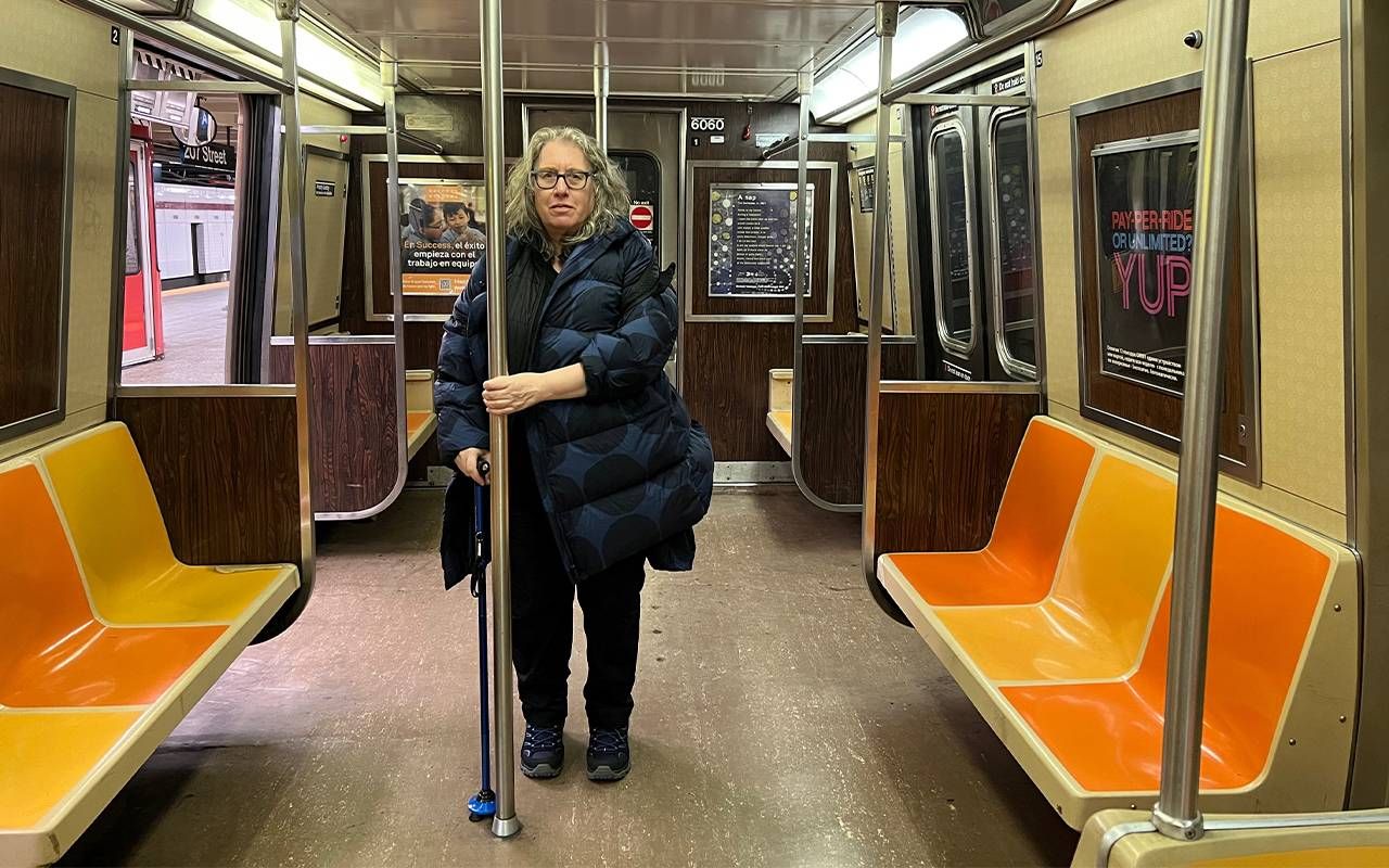 A person with a cane standing on the subway. Next Avenue, cane, accessibility, nyc