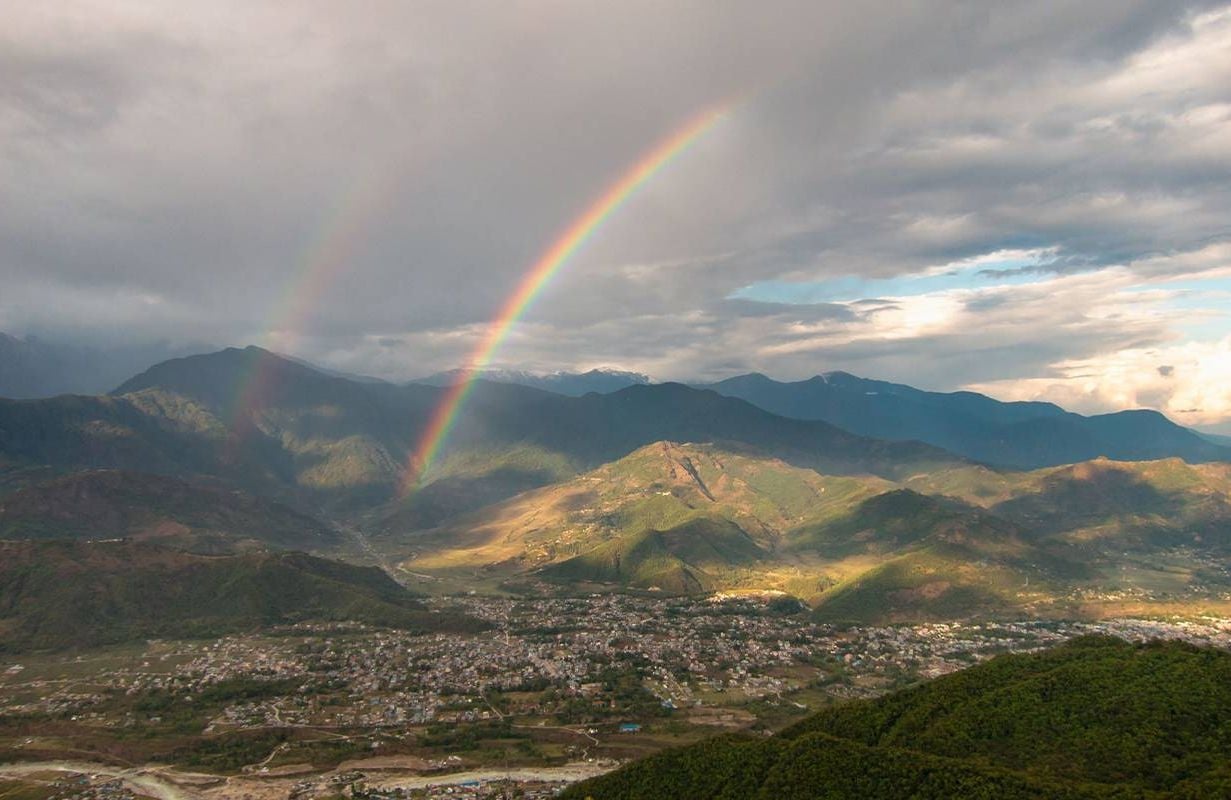 A double rainbow over a city. Next Avenue, optimism, longevity, living longer
