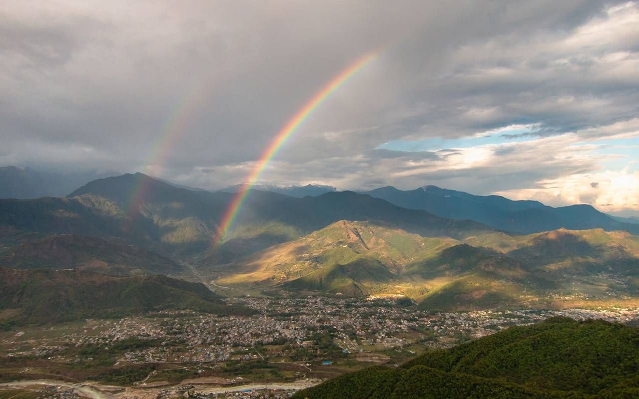 A double rainbow over a city. Next Avenue, optimism, longevity, living longer