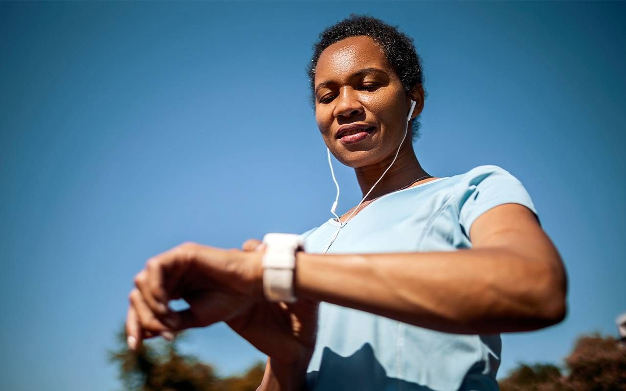 A woman checking her smart watch. Next Avenue, wearable technology