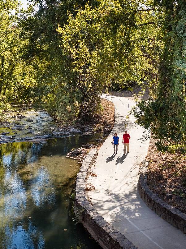 Two people walking on a paved path. Next Avenue, travel, hot springs arkansas