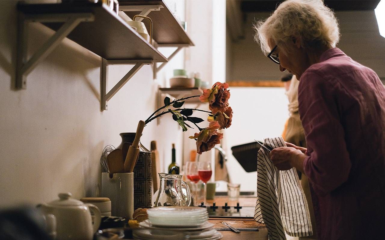 A woman doing the dishes at home. Next Avenue, cleaning, anxiety