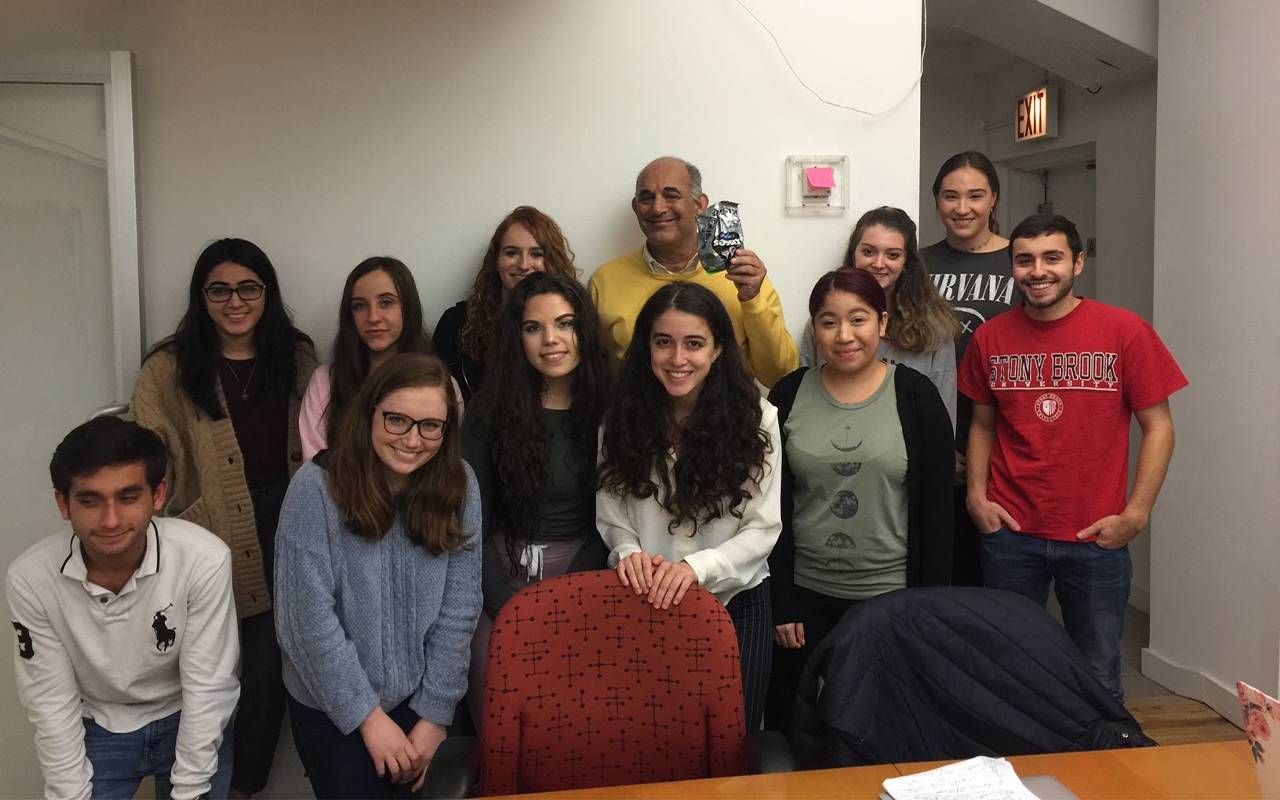 A man standing with several college students. Next Avenue