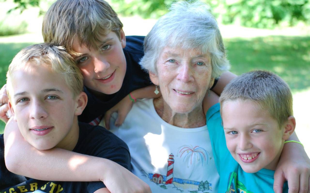 A grandmother smiling with her grandchildren. Next Avenue