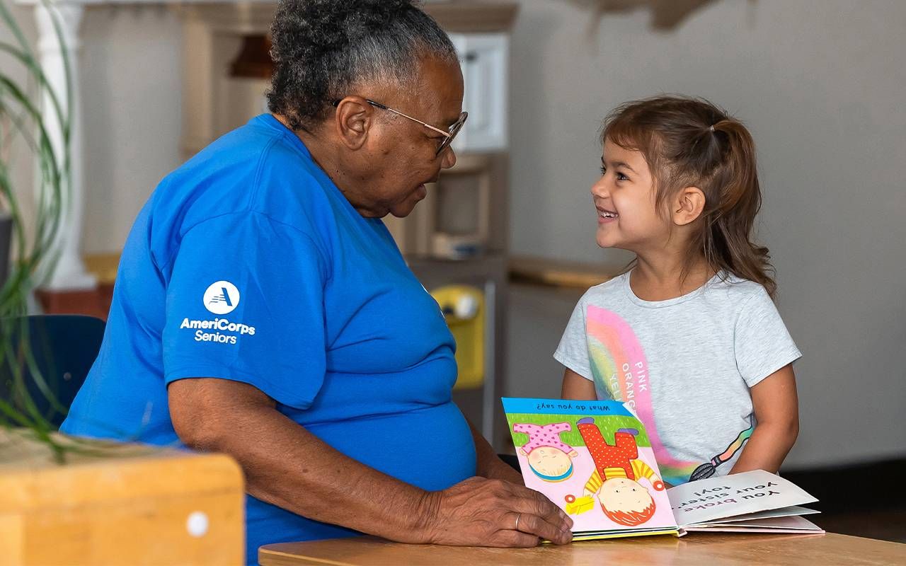 An older adult reading to a child. Next Avenue