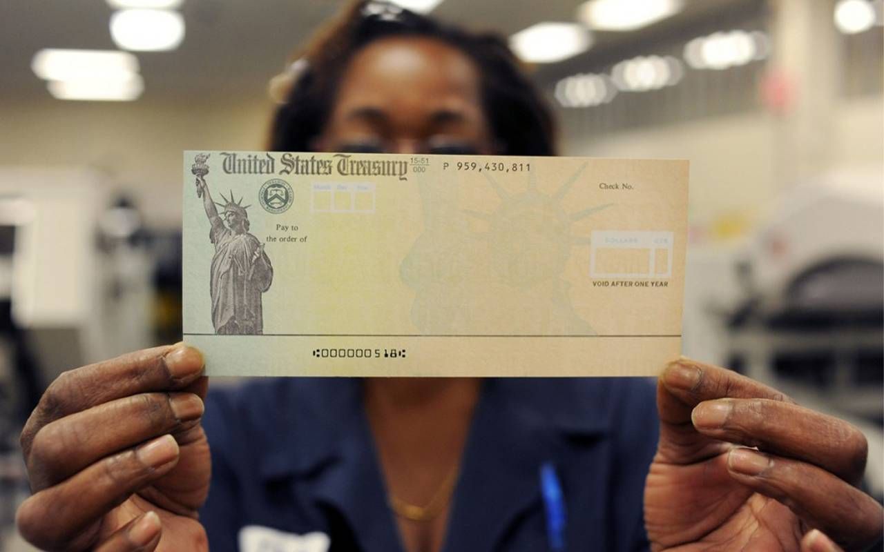 A person holding up a blank social security check. Next Avenue