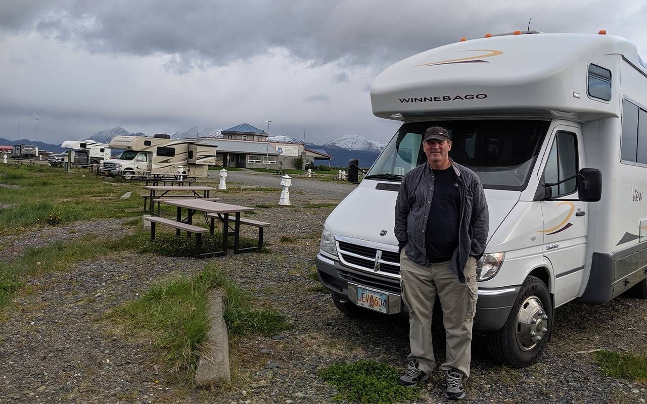 A man standing next to an RV. Next Avenue