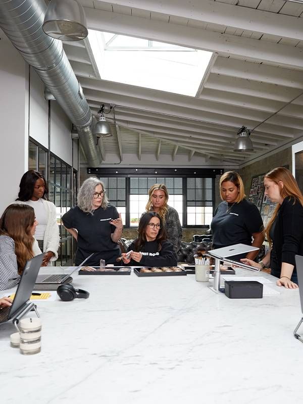 Bobbi Brown and her team working at a table. Next Avenue, jones road, makeup, business