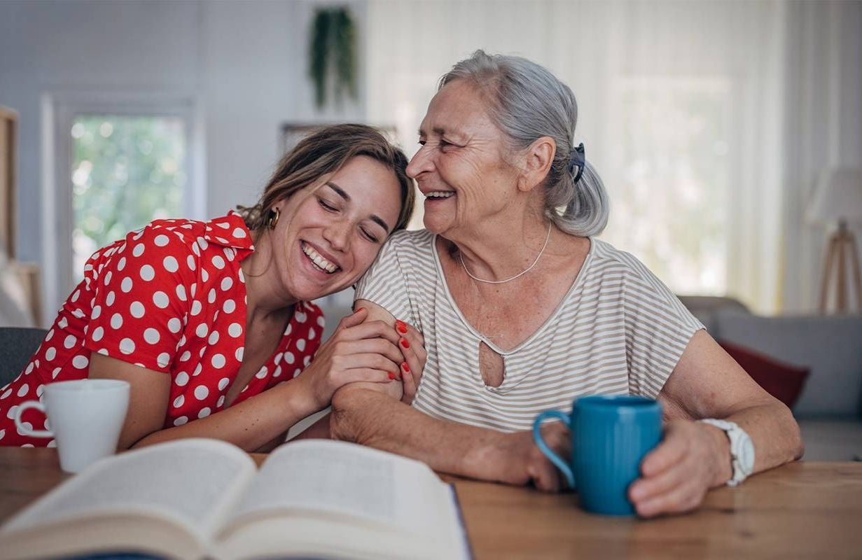 A young woman laughing and smiling with her grandmother who has dementia. Next Avenue