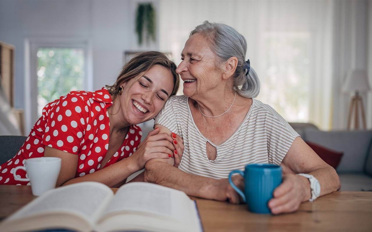 A young woman laughing and smiling with her grandmother who has dementia. Next Avenue
