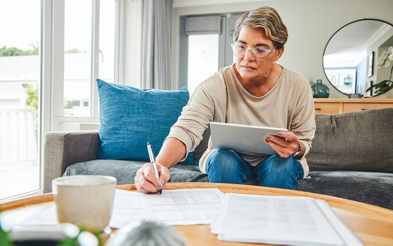 A woman calculating her retirement budget. Next Avenue