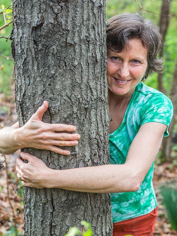 Headshot of a woman hugging a tree. Next Avenue