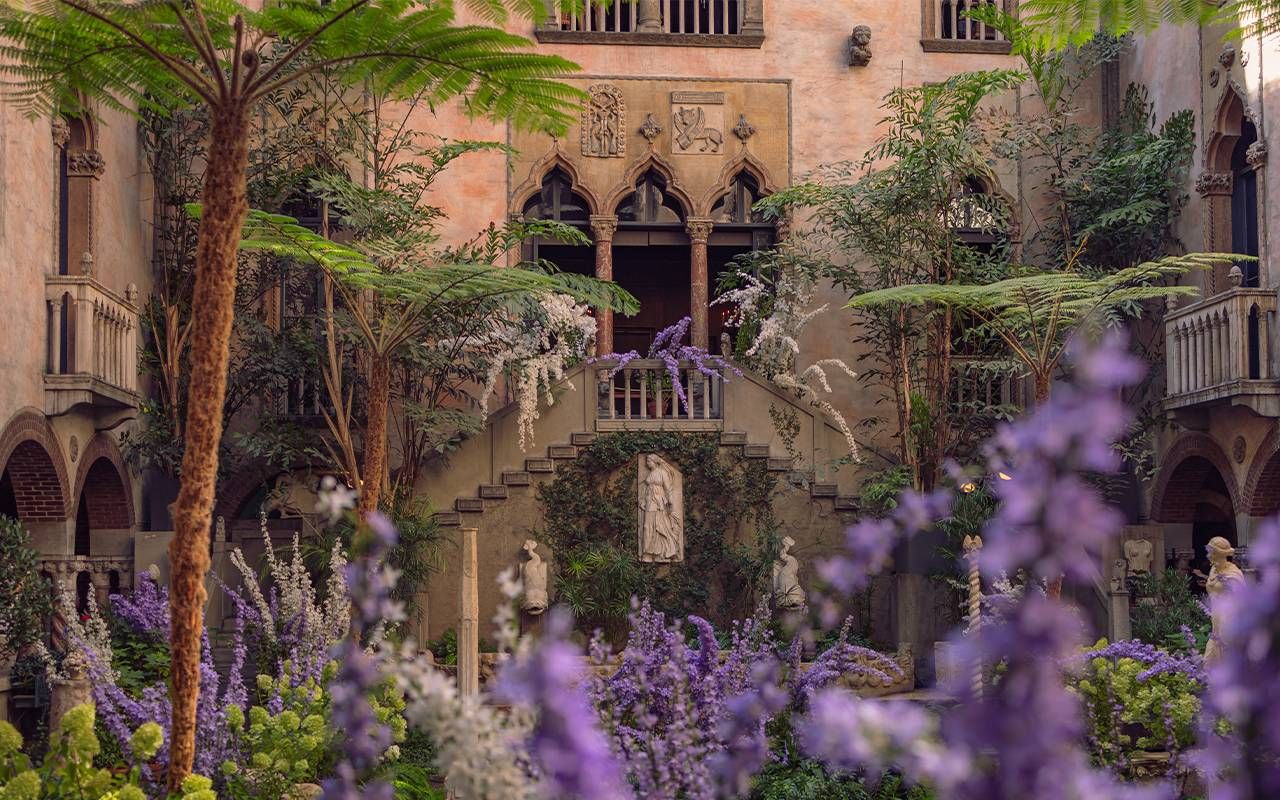 A courtyard in a museum with hydrangeas and purple flowers. Next Avenue