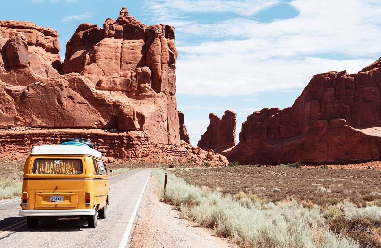 A yellow Volkswagon at the entrance to Arches National Park in Utah. Next Avenue