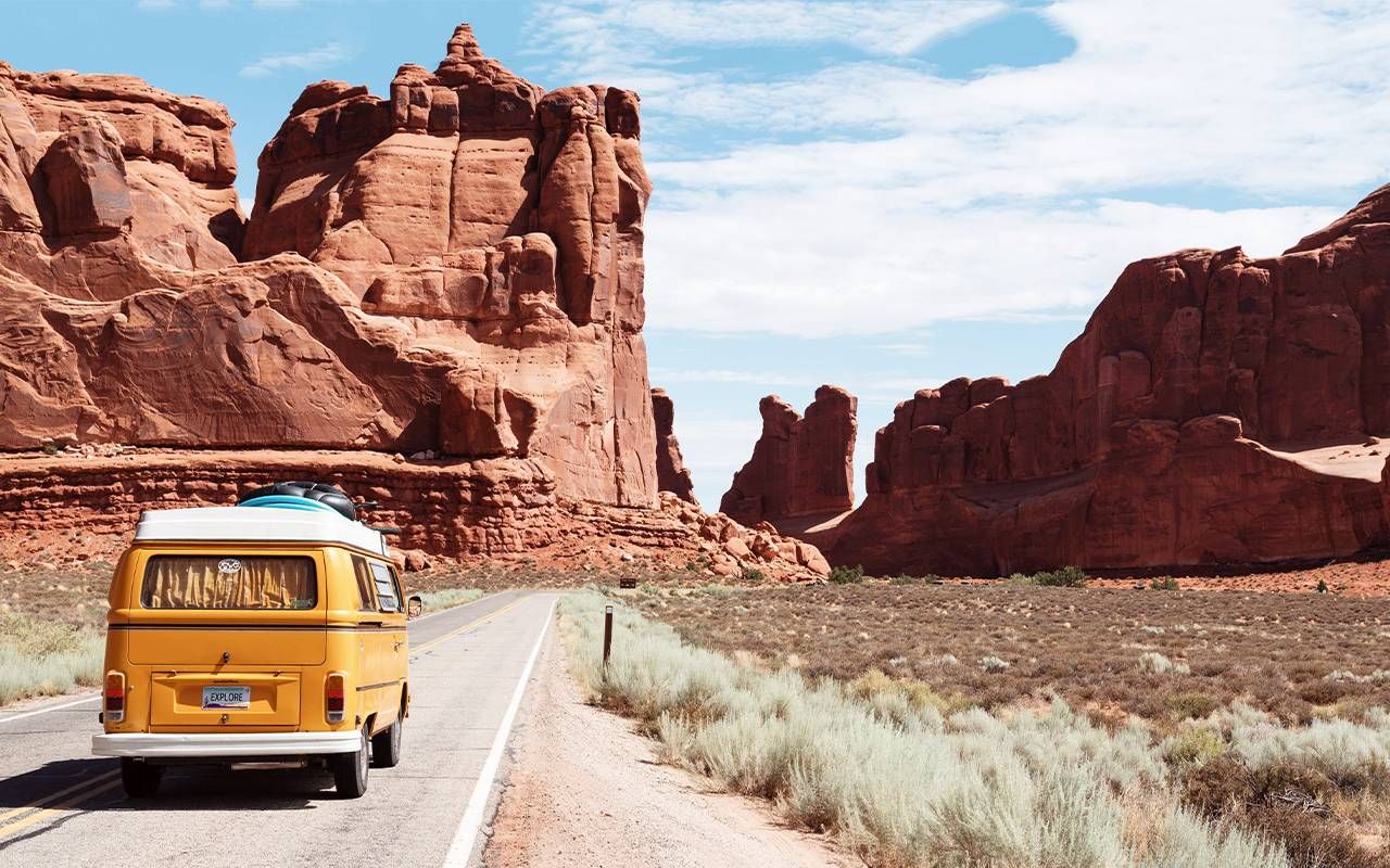 A yellow Volkswagon at the entrance to Arches National Park in Utah. Next Avenue