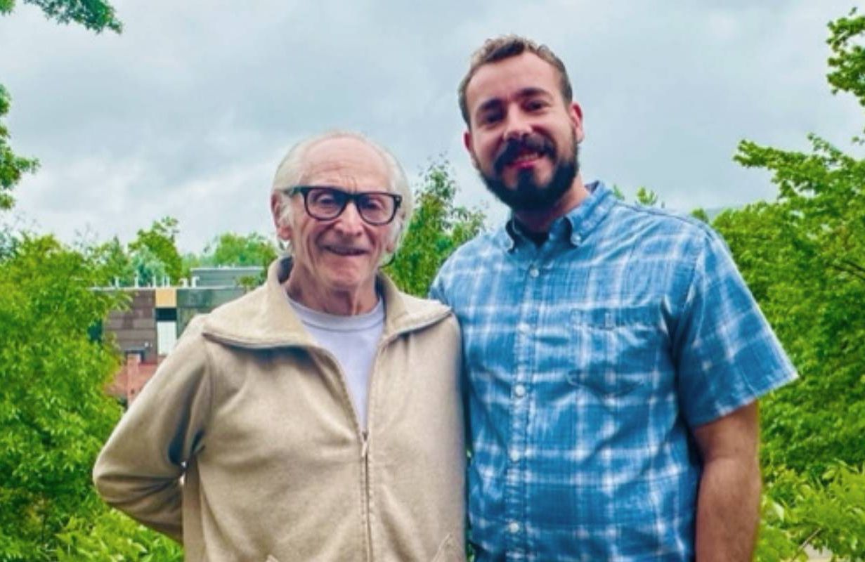 Two men standing next to each other and smiling. Next Avenue