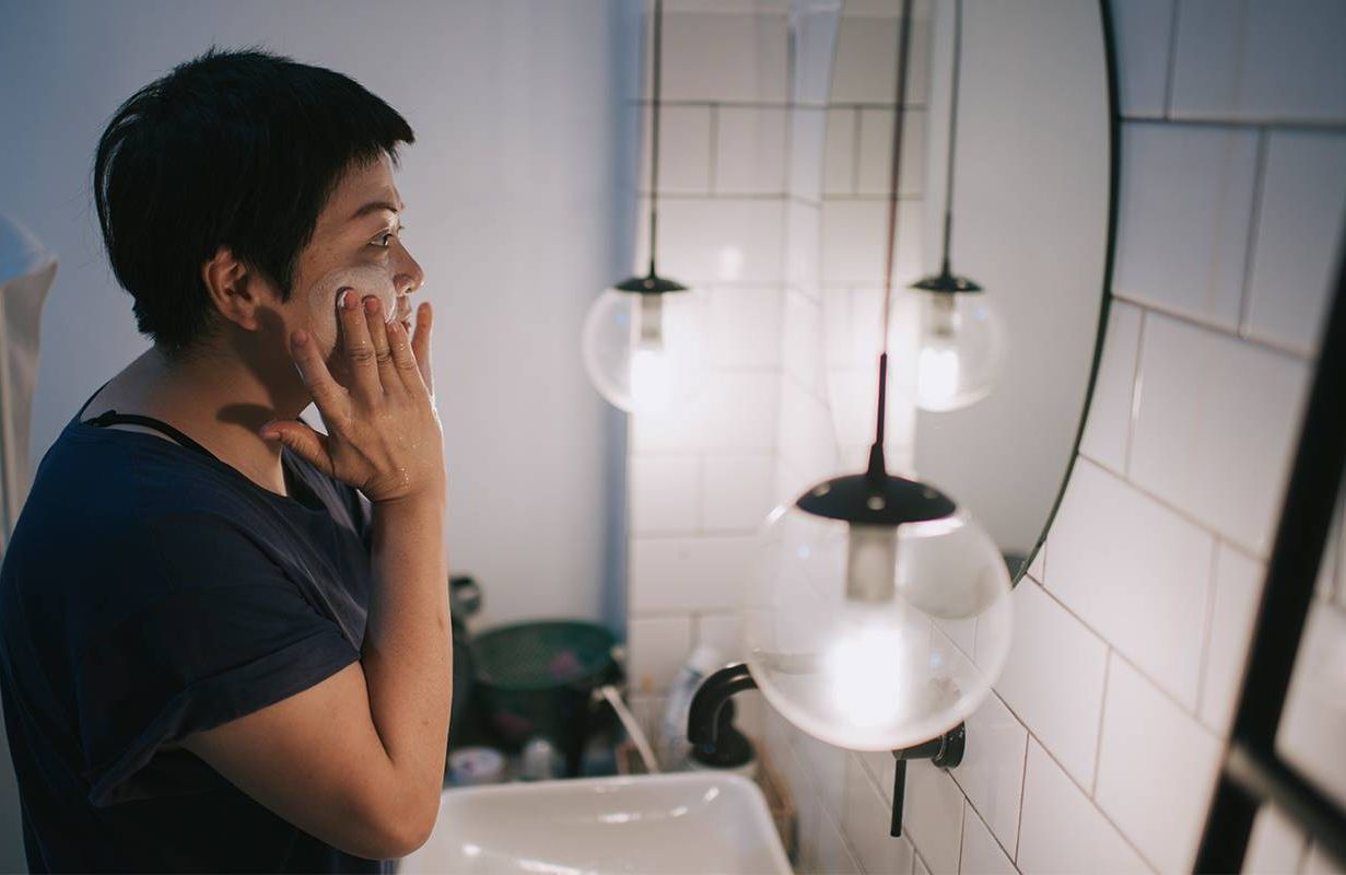 A woman washing her face. Next Avenue, menopausal acne