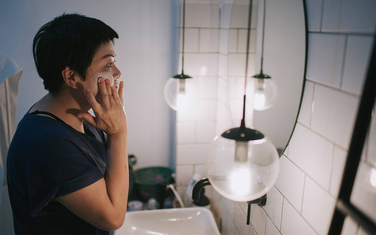 A woman washing her face. Next Avenue, menopausal acne