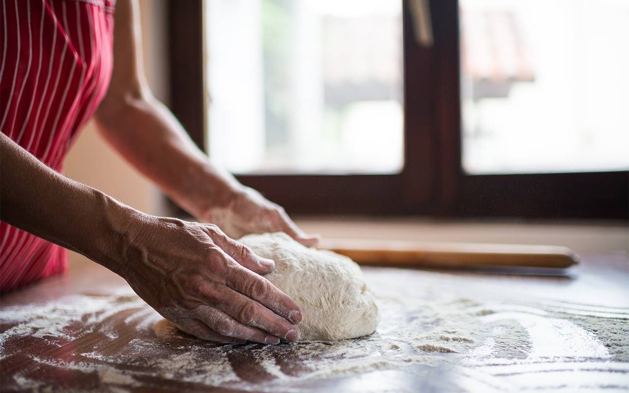 A woman kneading pizza dough. Next Avenue