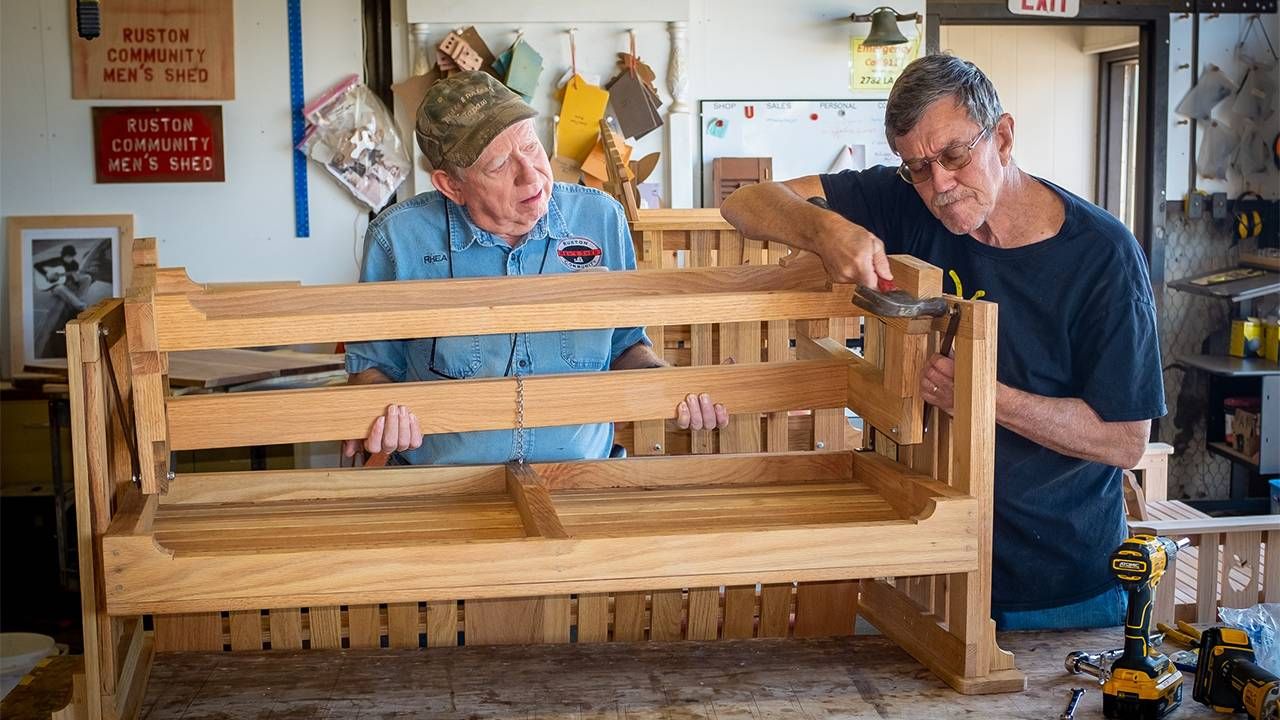 Two men building a wooden bench. Next Avenue, men's shed
