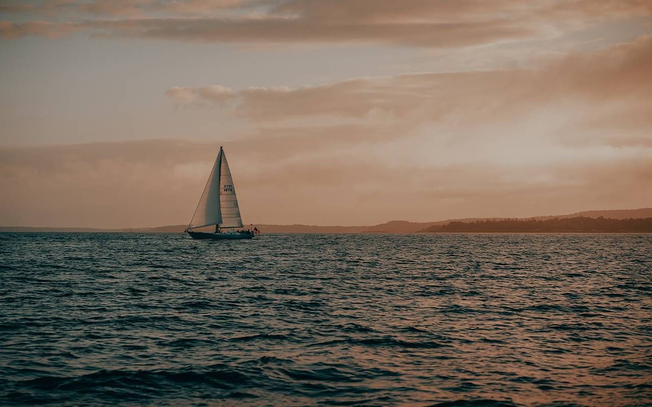 A sailboat during sunset. Next Avenue