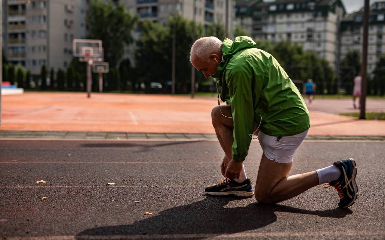 man tying his shoe laces. Next Avenue, foot pain