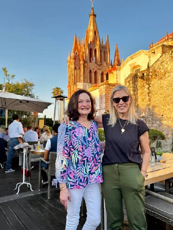 Two women smiling together outside. Next Avenue, expat