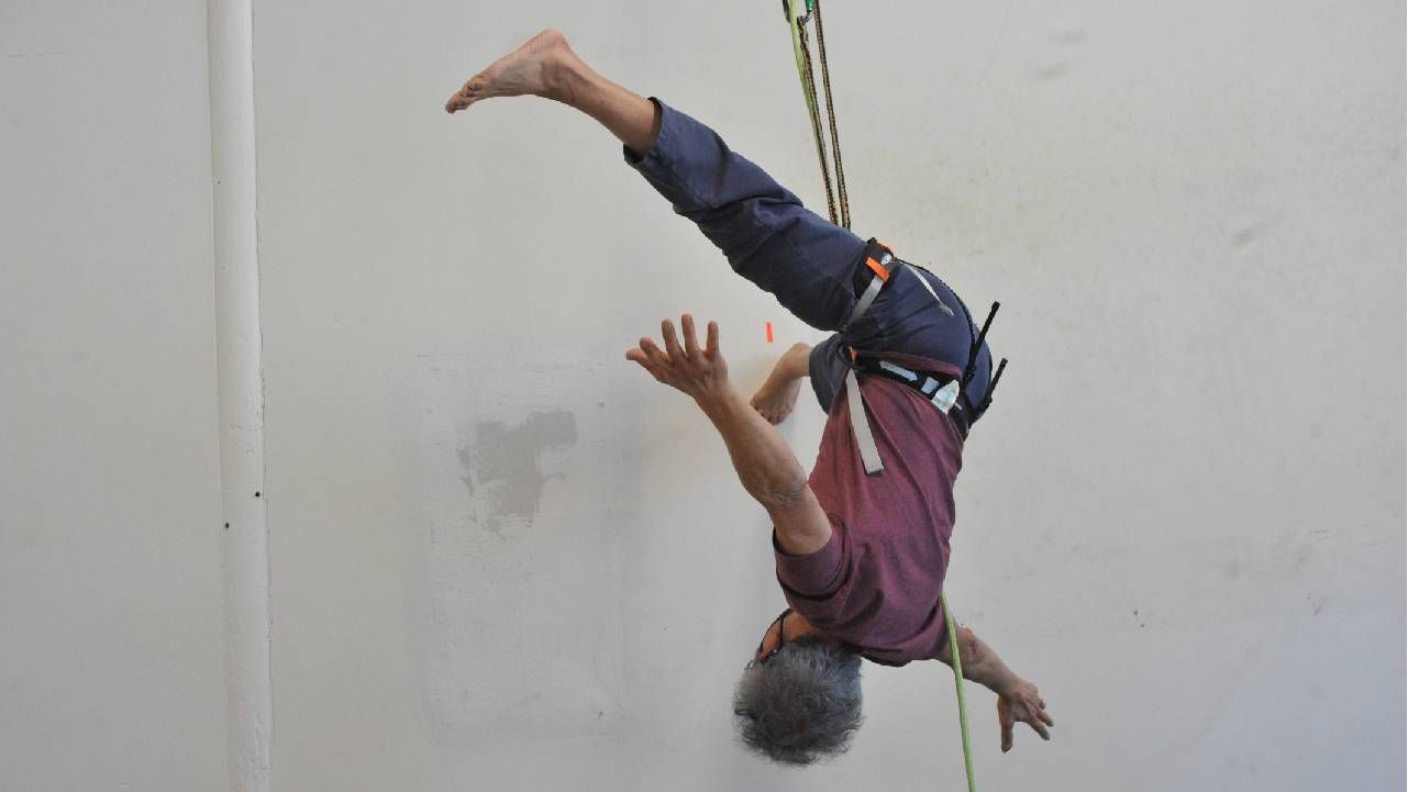 A person hanging upside down by a belay. Next Avenue, Vermont, Art communities