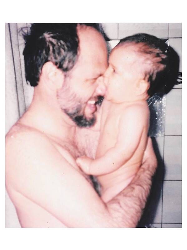 An older photo of father cuddling a baby. Next Avenue