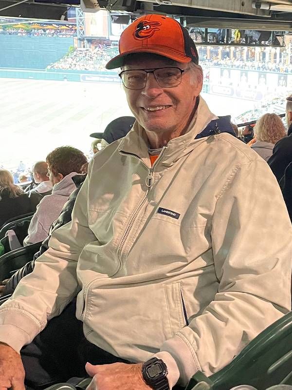 A headshot of a man at a baseball game. Next Avenue