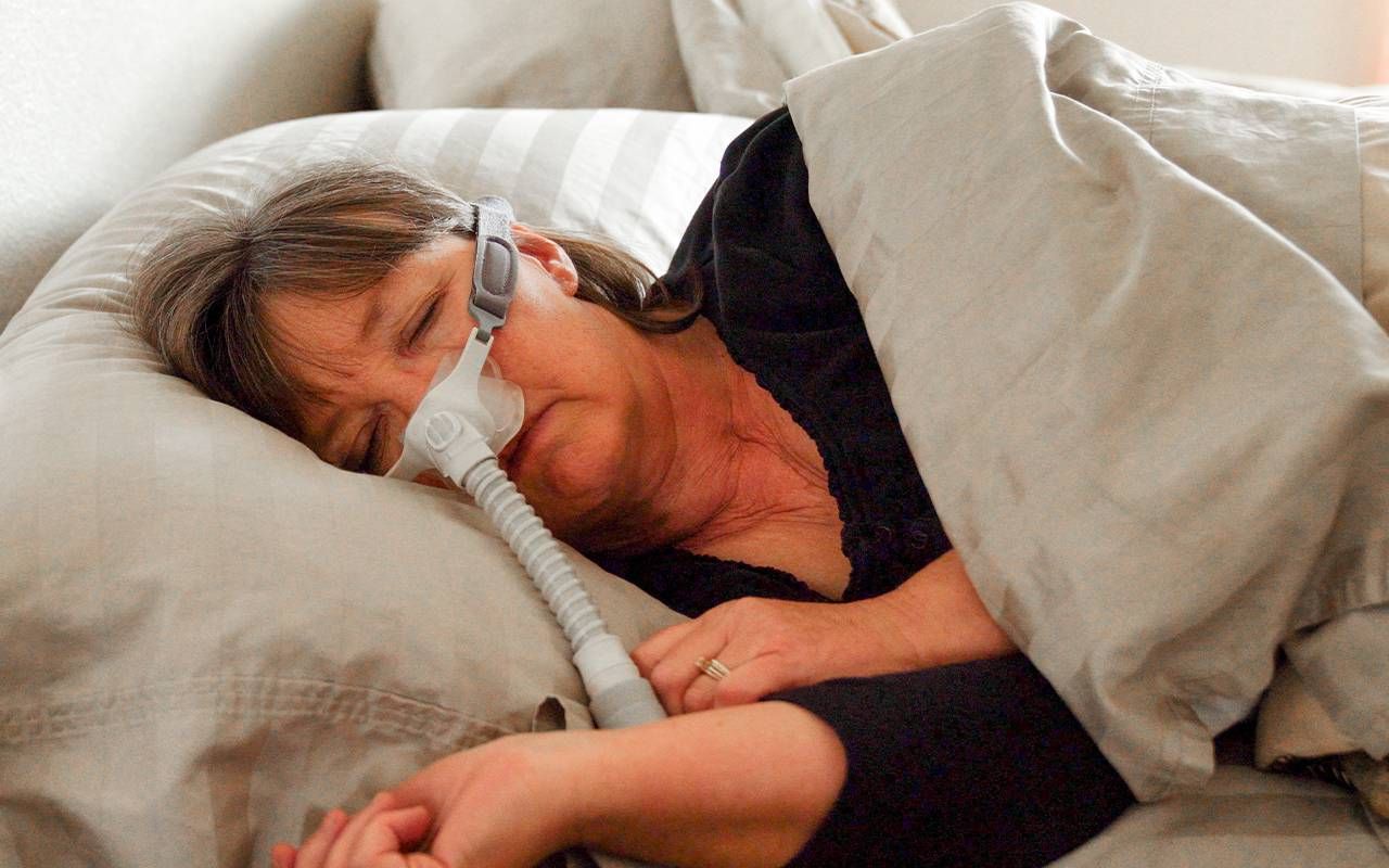 A woman sleeping with a CPAP machine. Next Avenue