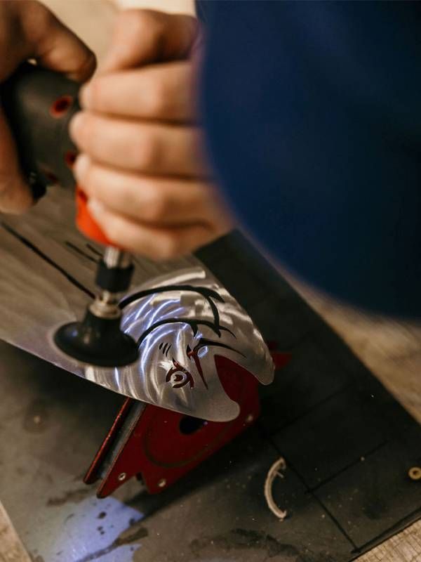 A person using a tool to create a metal piece of art. Next Avenue