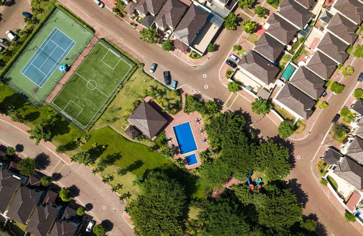 An aerial view of a pool and tennis court. Next Avenue