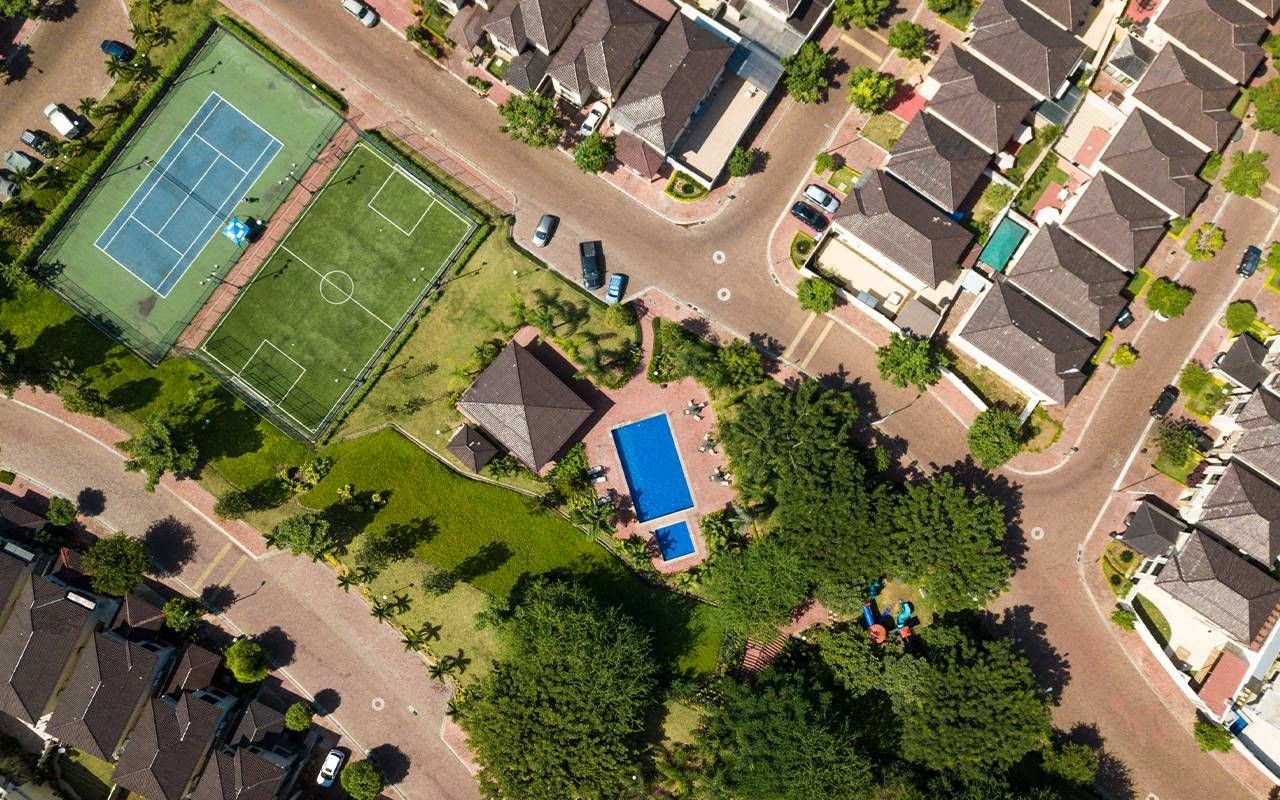 An aerial view of a pool and tennis court. Next Avenue