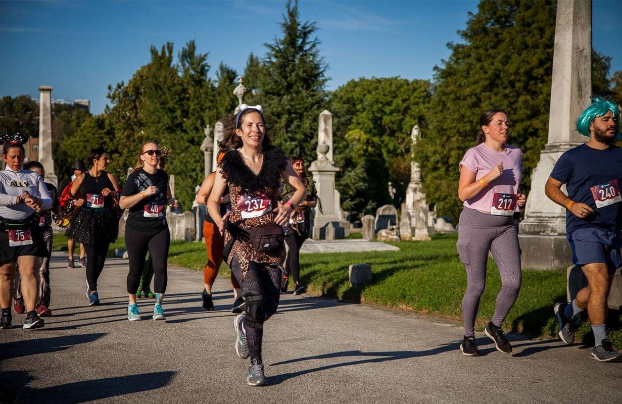 Runners wearing costumes during a race through a cemetery.Next Avenue, gravestone tourism