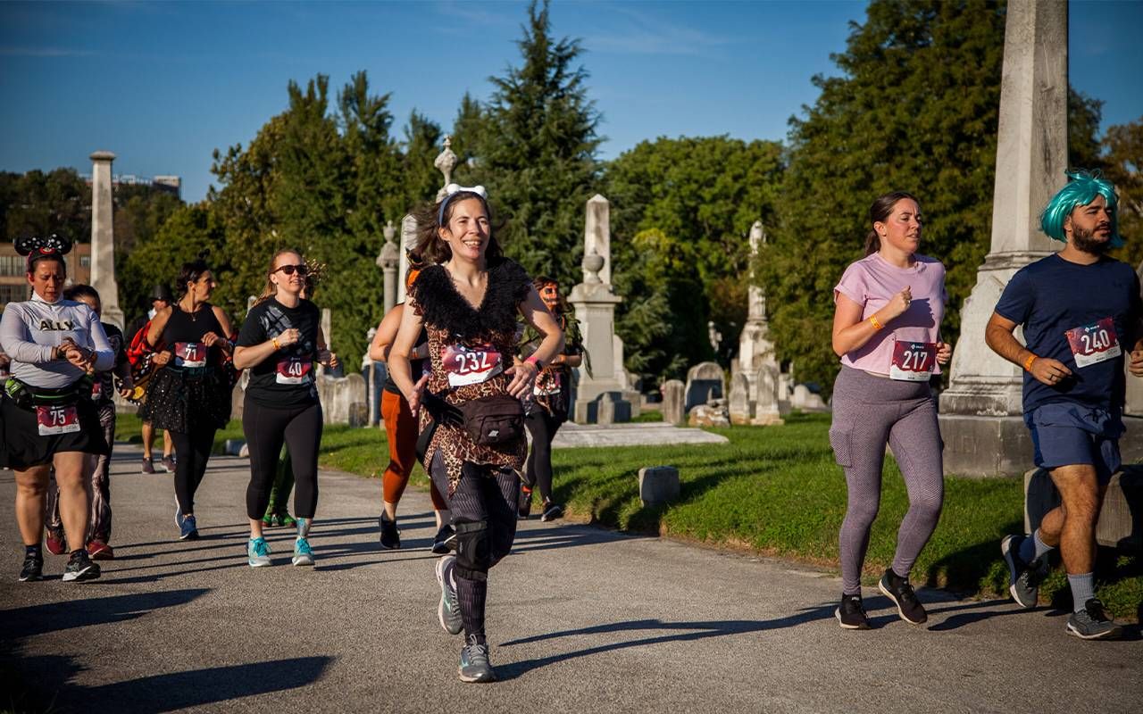 Runners wearing costumes during a race through a cemetery.Next Avenue, gravestone tourism