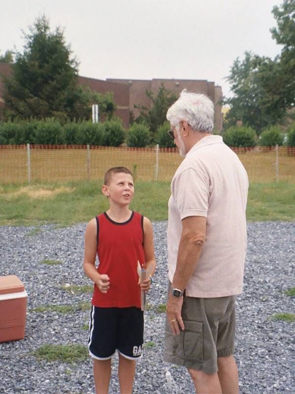A young boy and his grandfather talking outside. Next Avenue