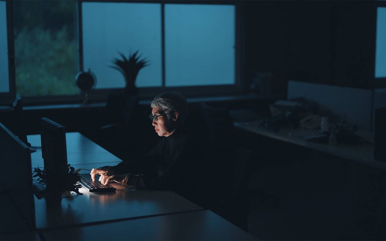 A business entrepreneur working late at night. Next Avenue, work life balance.