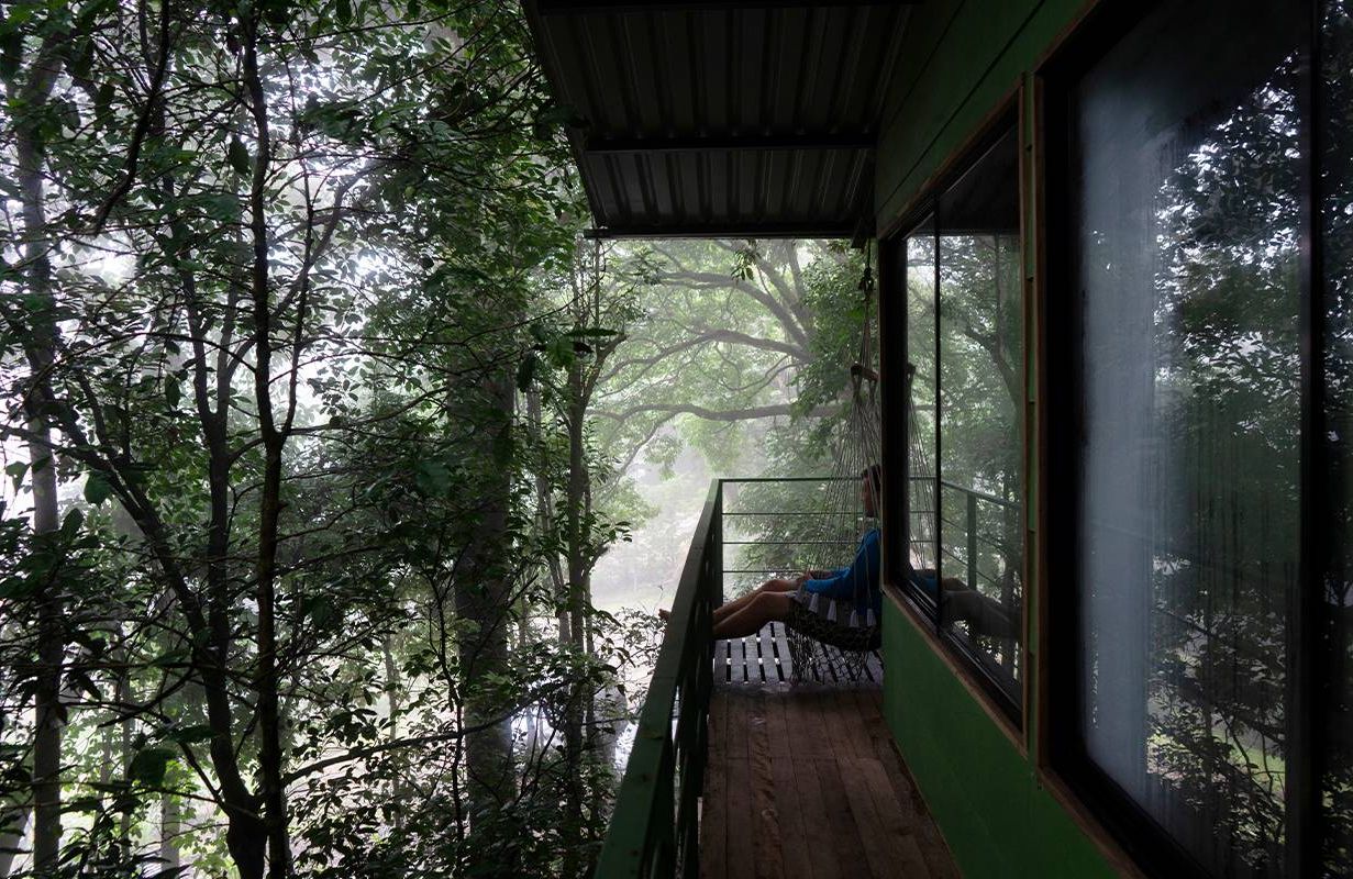 A person sitting outside on a balcony overlooking a jungle in Costa Rica. Next Avenue, blue zones