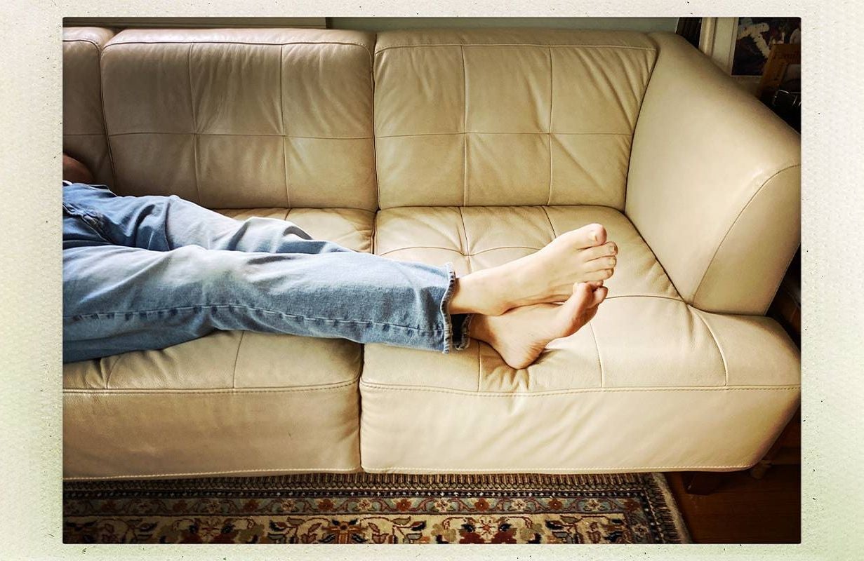 A photo of a person's legs and feet propped up on the couch. Next Avenue, empty nest