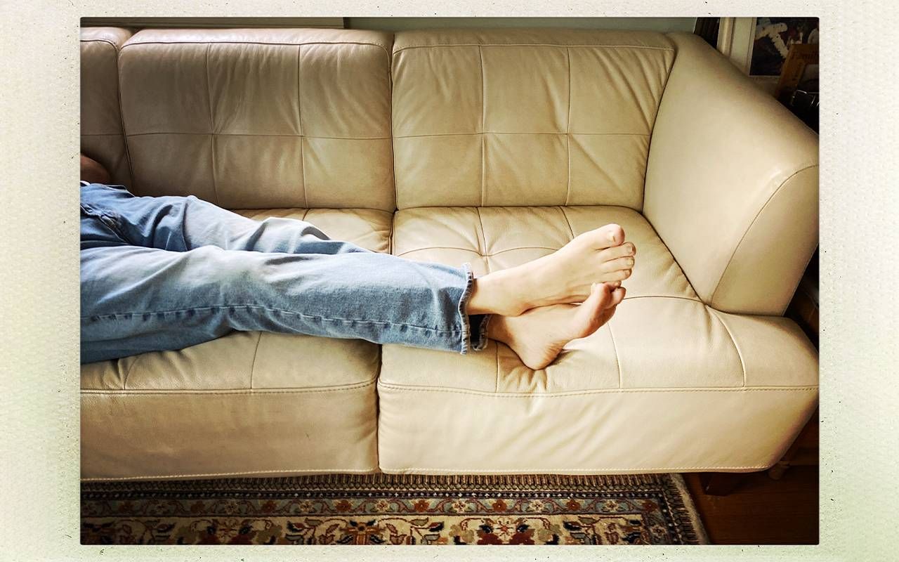 A photo of a person's legs and feet propped up on the couch. Next Avenue, empty nest
