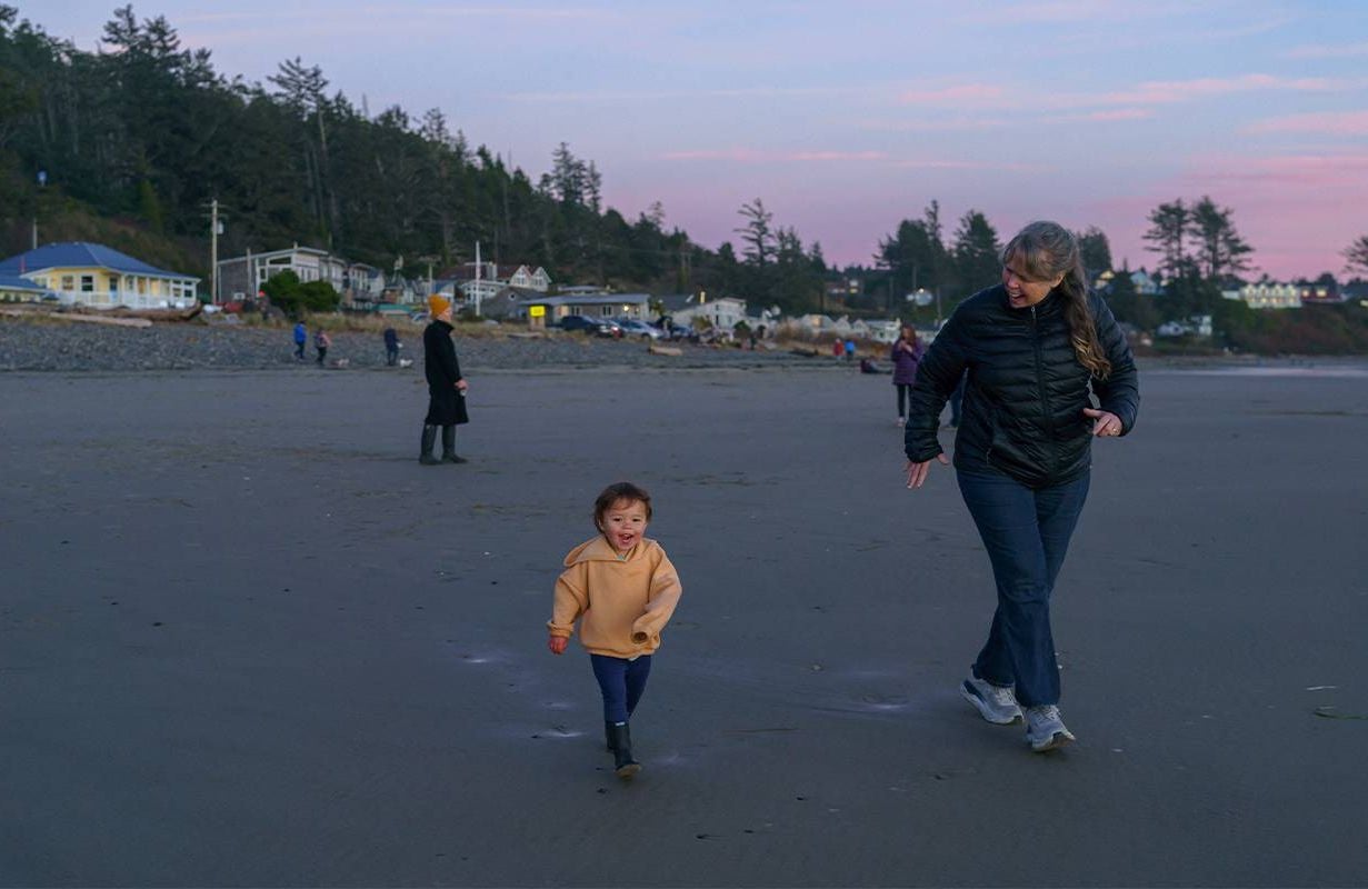 A grandmother and her grandchild running on the beach. Next Avenue
