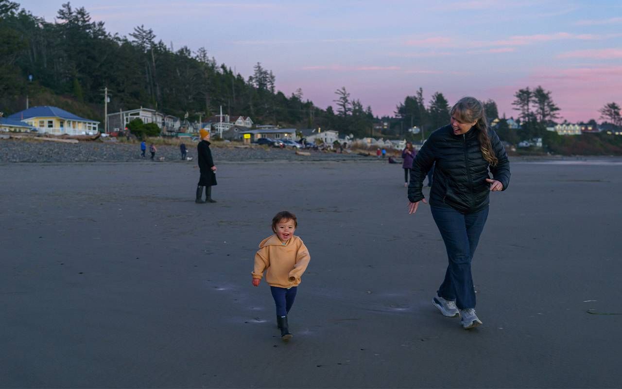 A grandmother and her grandchild running on the beach. Next Avenue