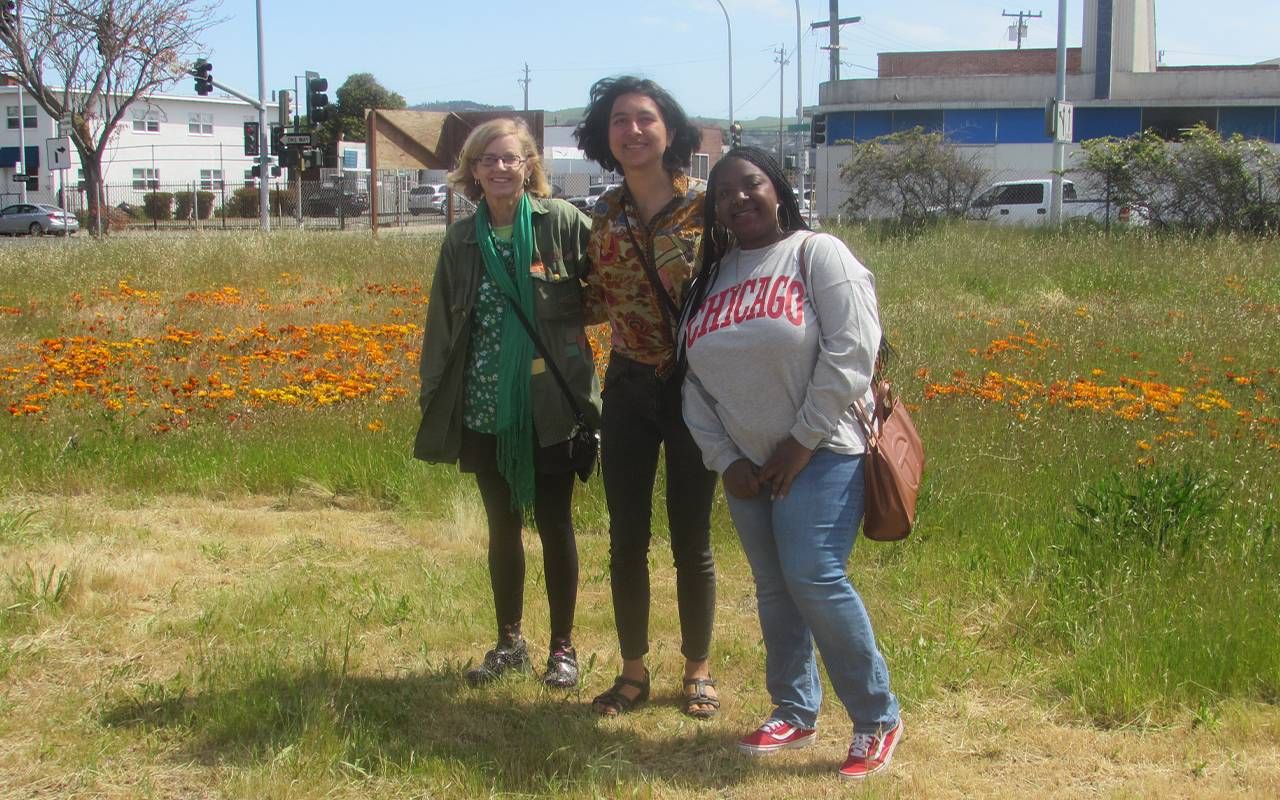 Three people smiling together in a field. Next Avenue