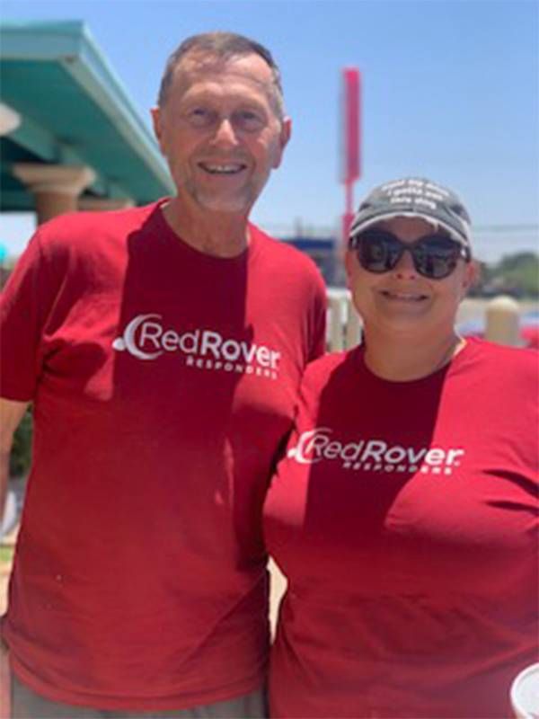 Two people smiling and wearing matching red shirts. Next Avenue