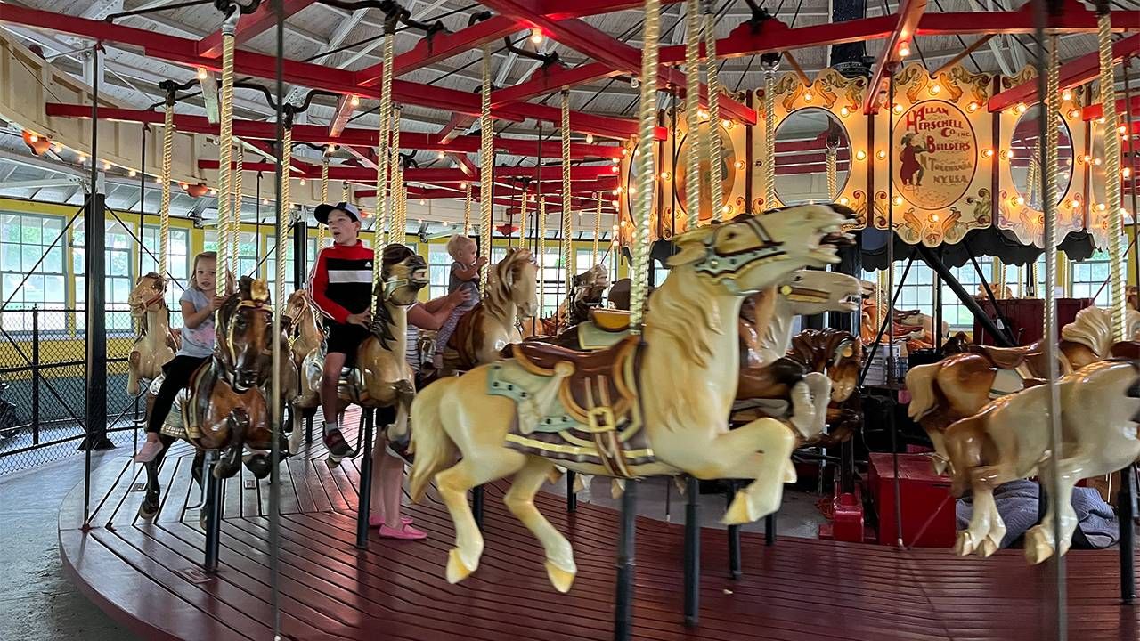 A colorful photo of a traditional looking carousel. Next Avenue, twilight zone
