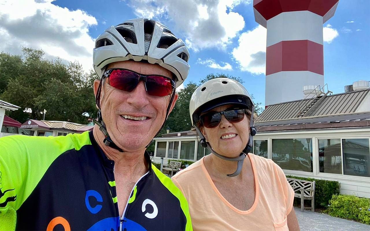 An older couple smiling while on a bike ride. Next Avenue