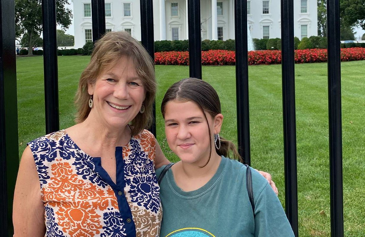 A grandmother and granddaughter pose in front of the White House. Next Avenue