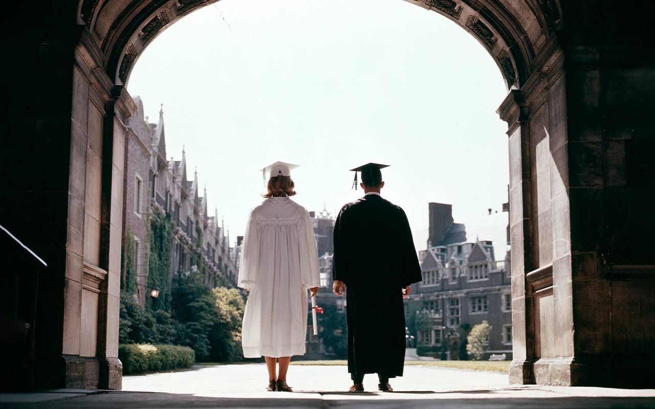 A rear view of two college graduates. Next Avenue, loan forgiveness, student loans