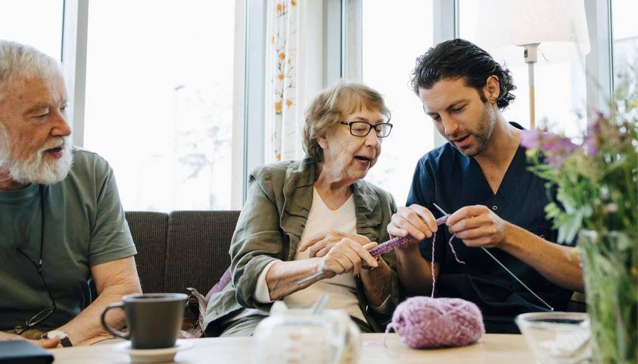 A male caregiver learning how to knit with his loved one. Next Avenue